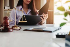 Article 1 Legal professional in Thailand preparing a legal complaint with documents and law books, offering guidance to foreign clients on navigating the legal system.
