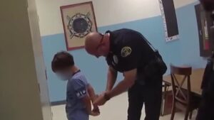Article 1 A Thai police officer explaining legal rights to a detained minor in a police station, ensuring compliance with child protection laws.